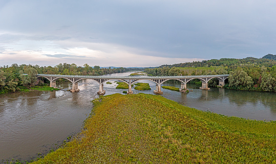 View of a bridge over the river Po in Piedmont in the drought summer of 2022 during the day at low water level