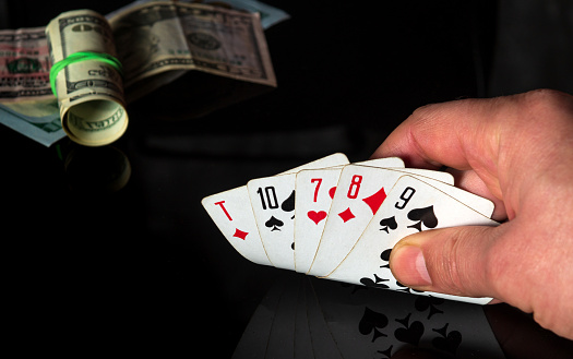 A fanned out suit of four black casino aces playing cards with glowing gold markings on a dark background - 3D render