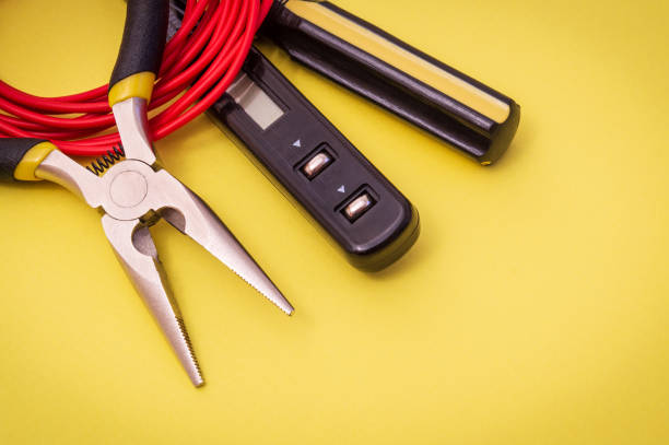 istock Electrician tool and red wire on yellow background for repairing energized systems or communications 1428645632
