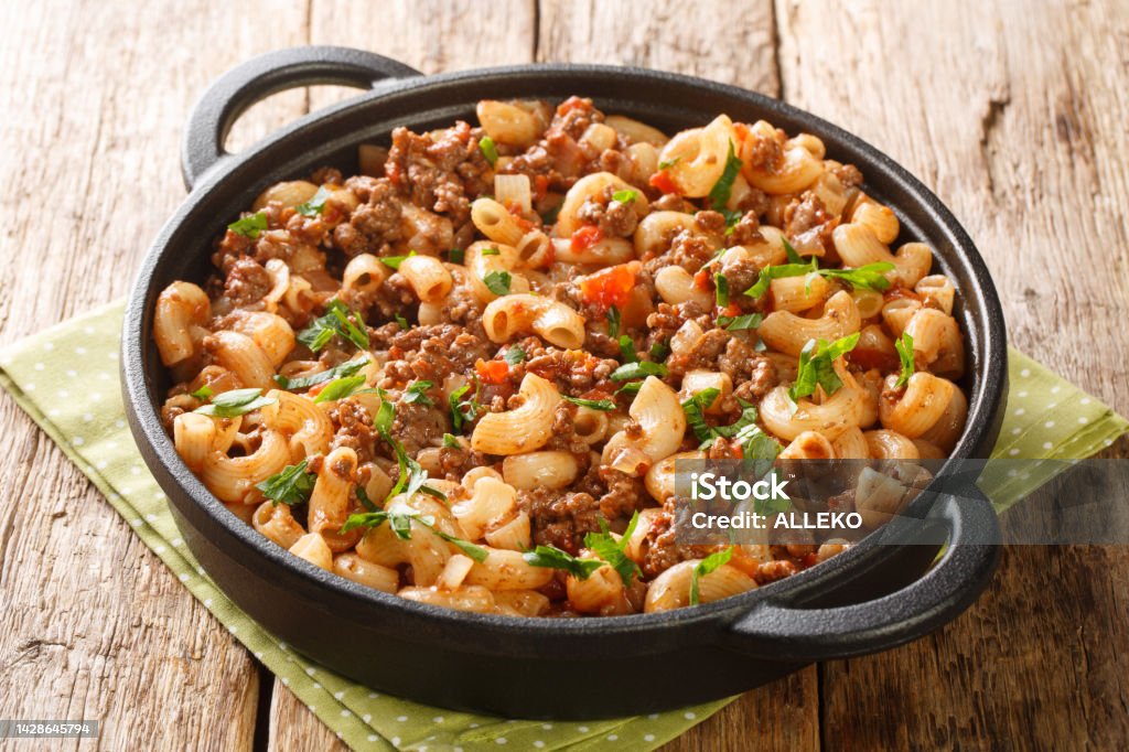 American Hamburger Goulash with Elbow Macaroni closeup in the pan. Horizontal American Hamburger Goulash with Elbow Macaroni closeup in the pan on the wooden table. Horizontal Meat Stock Photo