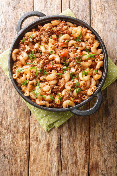 istock Hamburger and Macaroni closeup in the pan. Vertical top view 1428645824