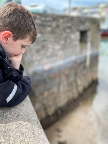 istock Thoughtful boy looking over wall at Brixham Harbour 1428646330