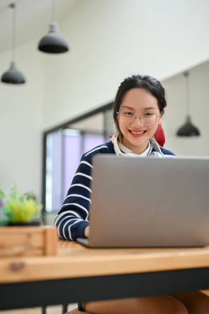 istock Asian female with eyeglasses using laptop, looking at laptop screen. 1428649242