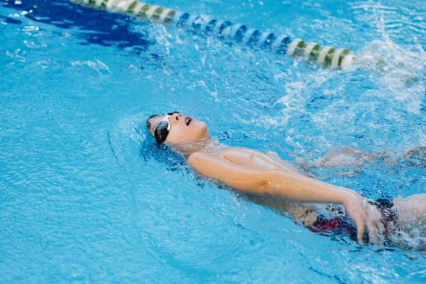 istock little caucasian boy wearing goggles swimming backstroke in a pool 1428649933