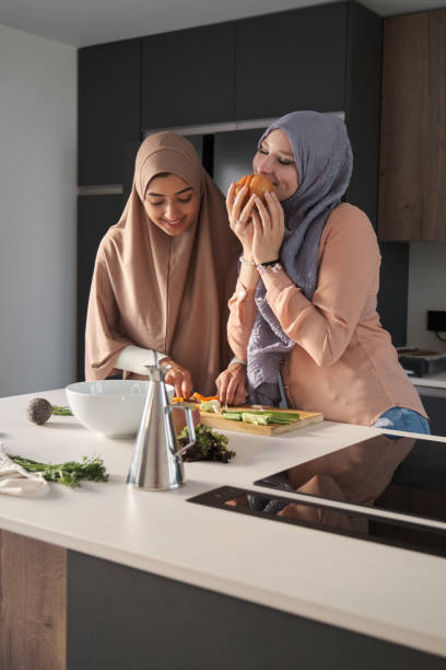 istock Two muslim women slicing, chopping and peeling vegetables at kitchen. 1428650995