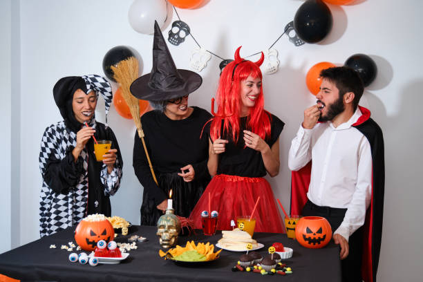istock Four people talking and laughing at a costume Halloween party. 1428651530