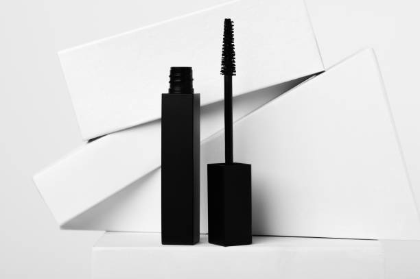 Mascara and brush with geometric shapes on white background Black mascara and brush with geometric shapes on white background. Luxury cosmetic product for eyes makeup. Beauty and fashion industry mascara stock pictures, royalty-free photos & images