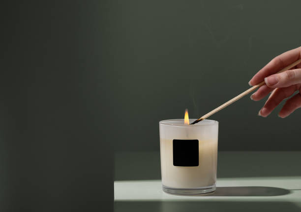 candela delle luci della donna con il bastone di legno su priorità bassa verde - aromatherapy candles foto e immagini stock