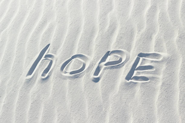 hope written with a finger on the white sand. concept, word on sand