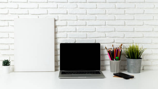 istock mockup laptop computer with blank white screen, with workspace and office supplies on a wooden desk 1428655937