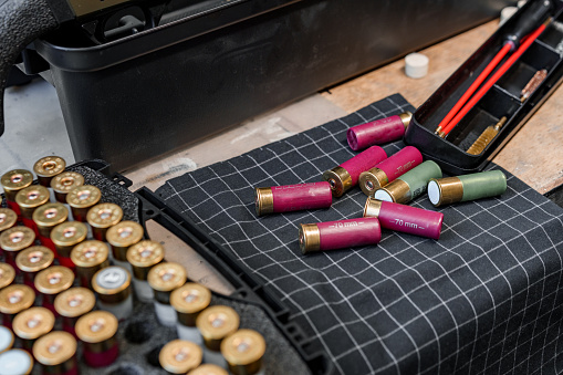 Shotgun shells on wooden table in a workshop close up