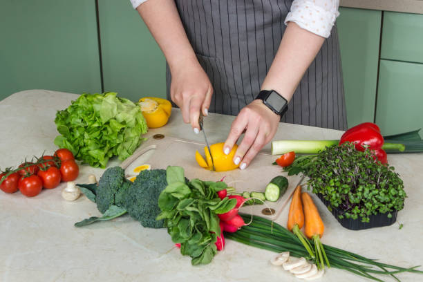 istock Woman cutting fresh vegetables for salad in kitchen 1428666672