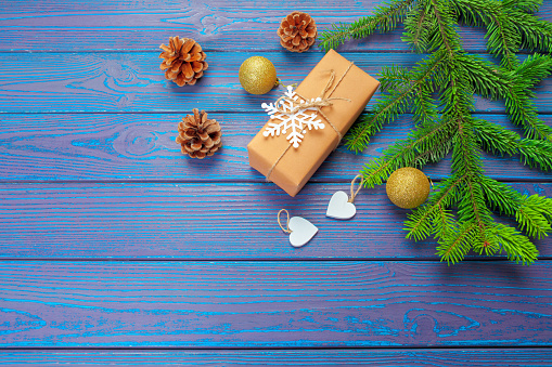 Christmas decoration, gift box and pine tree branches on wooden background