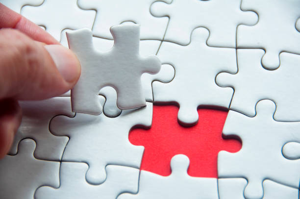 istock White jigsaw puzzle on red cover background with customizable space for text or idea. Copy space and puzzle concept 1428672836