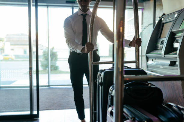 istock Hotel attendant taking luggage into hotel. 1428673502