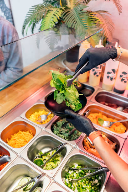istock Woman Adding Ingredients Into Poke Bowl 1428677044