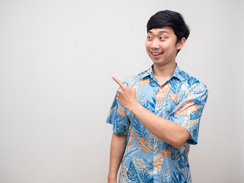 Young man beach shirt smile point finger at copy space