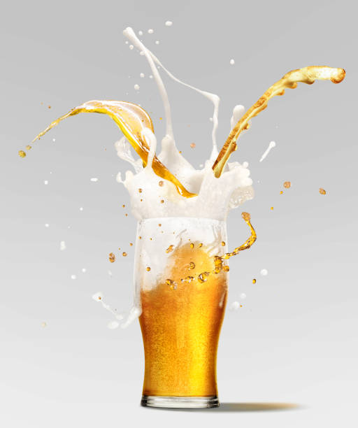 Foam splashes from full glass of frothy light lager beer isolated over light background. Concept of alcohol, Beer Fest, drinks, holidays and festivals. Foam splashes from full glass of frothy light lager beer isolated over light background. Concept of alcohol, Beer Fest, drinks, holidays and festivals. Copy space for ad. beer glass splash stock pictures, royalty-free photos & images