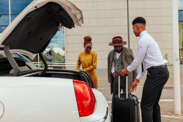 istock Valet helping wealthy couple with luggage. 1428687123