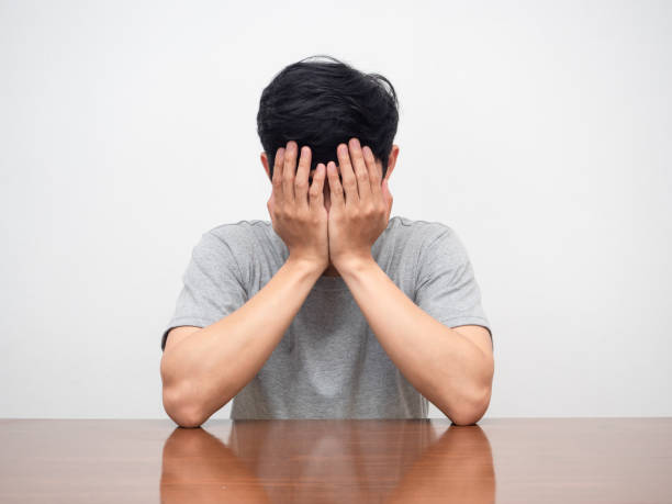 istock Depressed man sit close face at his working table white background 1428691220