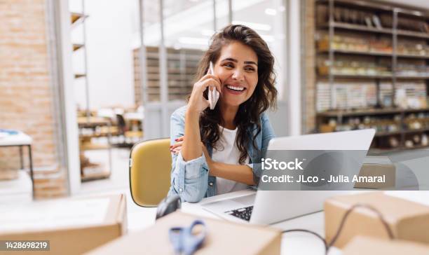 Happy Young Businesswoman Speaking On The Phone In A Warehouse Stock Photo - Download Image Now