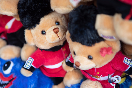 Stuffed animals placed together between some pillows. Teddy bears used as a decoration on a children birthday party. Close-up of four teddy bears in a kids room.