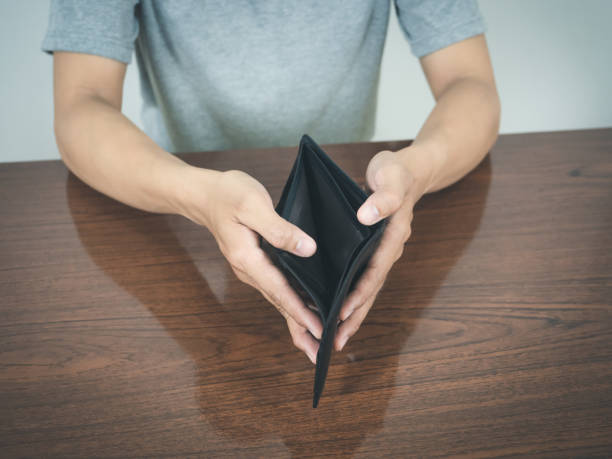 istock Man hands hold empty wallet no money on the table 1428702473