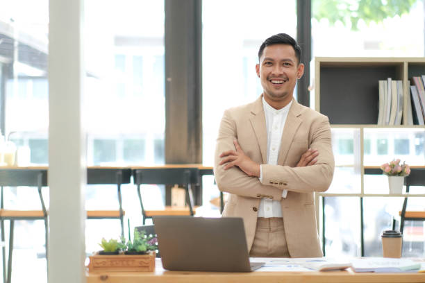 istock Asian businessman standing by his desk in office 1428711894