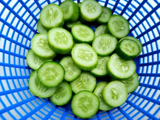 Sliced Cucumbers in Blue basket - food preparation. stock photo