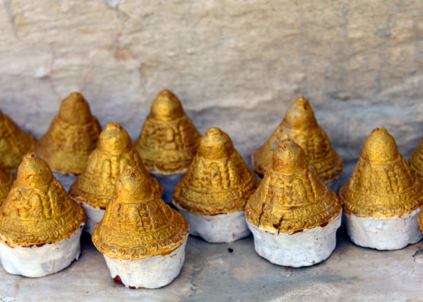 Tsa tsa cones - made with ashes of family member, are an homage to departed ancestors, Walakha, Bhutan Wolakha, Guma Gewog, Punakha district, Bhutan: golden tsa tsa cones deposited by Buddhist faithful near a stupa above the Puna Tsang Chhu river - Buddhist expression of farewell, moulded out of clay and the ashes collected from the cremation pyre, commissioned by the bereaved family, and made by monks during religious ceremonies. Votives in the shape of cylindrical cones or stupas. Some times called cupcakes. bhutanese culture photos stock pictures, royalty-free photos & images
