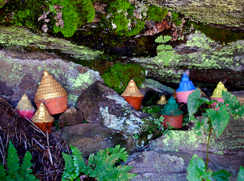 Paro district, Bhutan: golden 'tsa tsa' cones deposited by Buddhist faithful underneath rocks on the Tiger's Nest trail - Buddhist expression of farewell, moulded out of clay and the ashes collected from the cremation pyre, commissioned by the bereaved family, and made by monks during religious ceremonies. Votives in the shape of cylindrical cones or stupas.