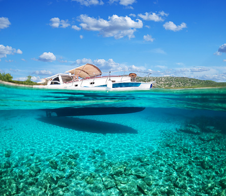 Split view - half underwater view of beautiful seabed with sea fishes and beautiful marine yacht, Turkey, Bodrum.
