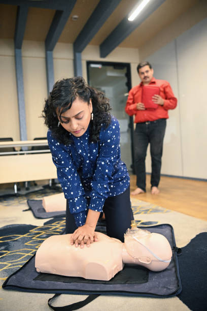 istock Female instructor demonstrating chest compressions on a mannequin during CPR training 1428722160