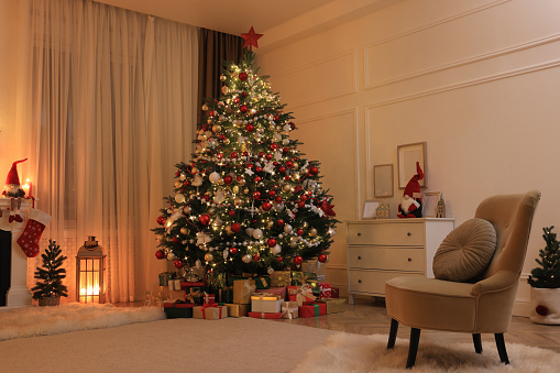 Festive living room interior with Christmas tree and comfortable armchair
