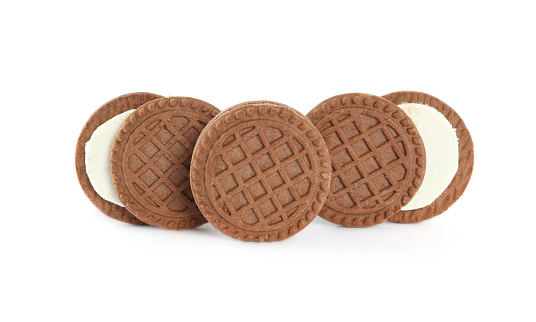 Tasty chocolate sandwich cookies with cream on white background