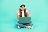 surprised teen girl use wireless laptop for video call or listen webinar in headphones, buy online