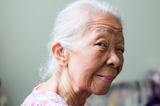 Senior elderly woman showing her hearing airs