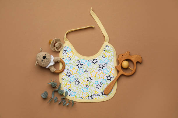 istock Flat lay composition with baby accessories and bib on brown background 1428728491