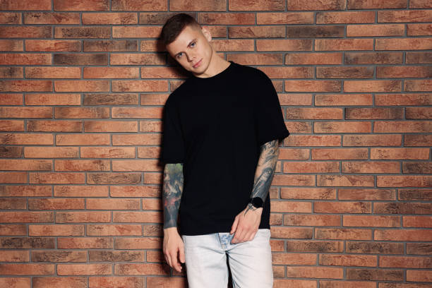 istock Young man with tattoos near brick wall 1428728626