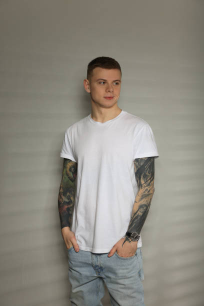 istock Young man with tattoos near light wall 1428730010