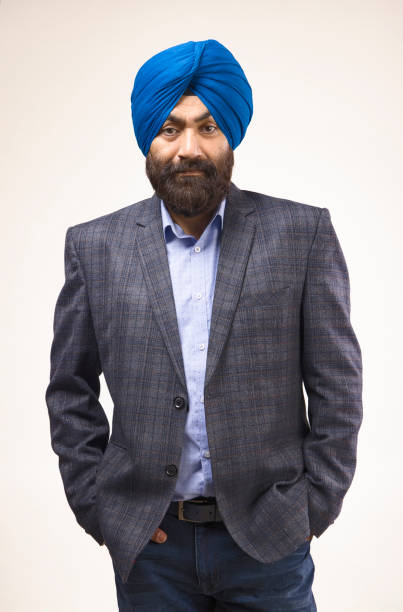 istock Sikh man with blue turban and grey jacket looking at camera and smiling, studio shot 1428730634