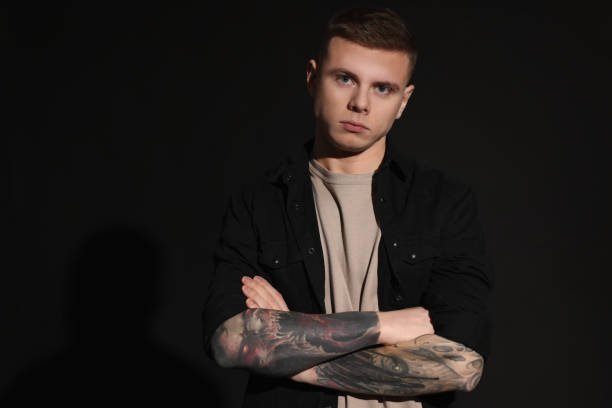 istock Young man with tattoos on black background. Space for text 1428730861