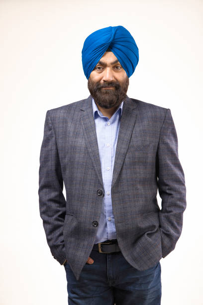 istock Sikh man with blue turban and grey jacket looking at camera and smiling, studio shot 1428730885