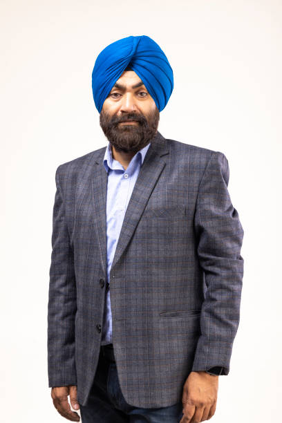 istock Sikh man with blue turban and grey jacket looking at camera and smiling, studio shot 1428731030