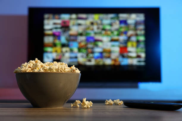 istock Bowl of popcorn and TV remote control on table indoors 1428733316