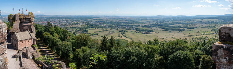 A panorama of hills with agricultural land near the village on the background of the distant mountains