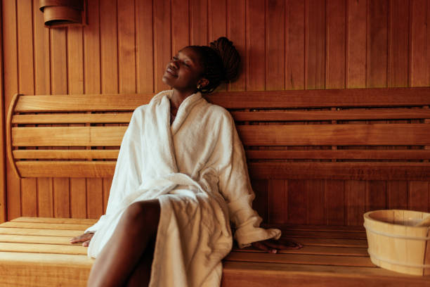 jeune femme noire profitant du sauna. - sauna health spa healthy lifestyle wellbeing photos et images de collection