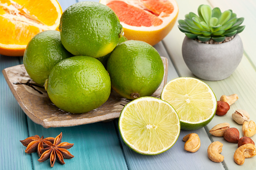 Whole lemon and halves of ripe fresh fruit with leaves on dark background. With copy space