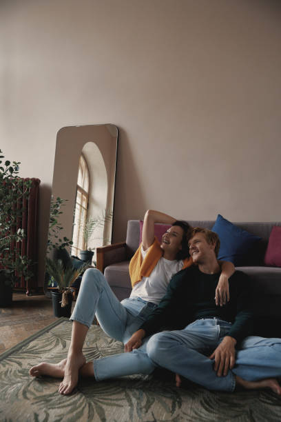 istock Dreamful young couple embracing and smiling while relaxing at home together 1428747573