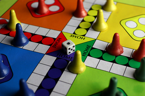 playing board games with dice, colorful board and pieces. red, blue, yellow and green. strategy games.